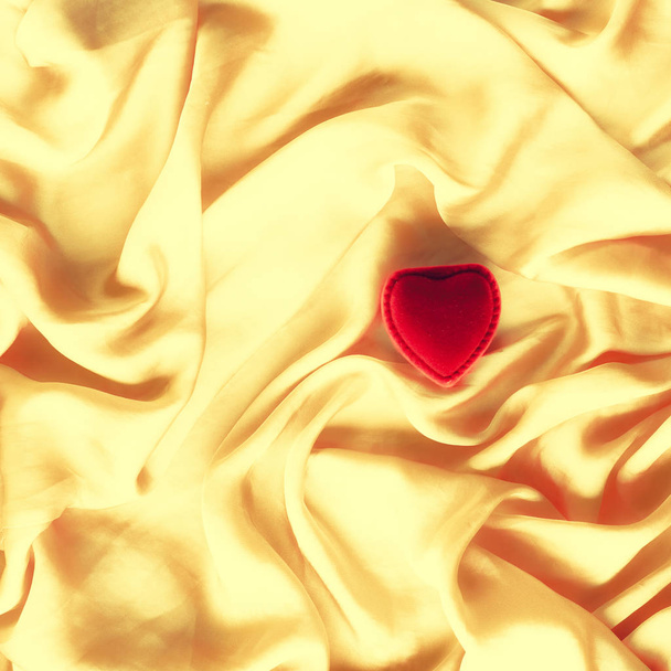 rote herzförmige Schmuckschatulle auf goldener Seide - Valentinstag, wahre Liebe, Verlobung und Heiratsantrag-Konzept. wirst du mich heiraten? - Foto, Bild