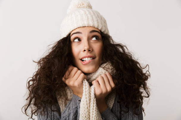 Cheerful young woman wearing winter scarf standing isolated over white background - Fotoğraf, Görsel