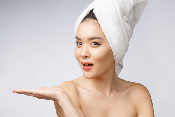 Портрет красивая азиатская женщина вау удивлен и указывая рукой на правую сторону на сером фоне, эмоции действия, показывая свой продукт или сообщение - Фото, изображение
