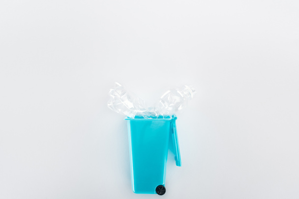 Top view of blue toy trashcan and empty plastic bottle   - Фото, зображення