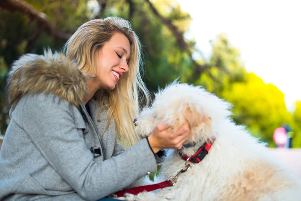 Chica joven con su perro en un parque
 - Foto, imagen