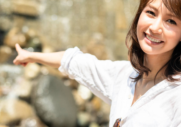 Lähemmäs. Onnellinen japanilainen nainen 30s näköinen kamera ja osoittaa oikealle
. - Valokuva, kuva
