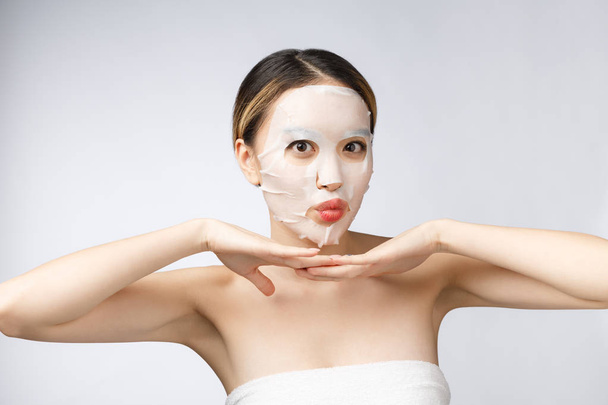 Spa, soins de santé. Asiatique fille avec un cosmétique masque isoler sur blanc. - Photo, image