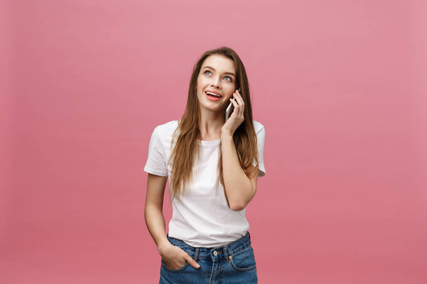 Cheerful young woman talking on mobile phone isolated on pink background - Fotoğraf, Görsel
