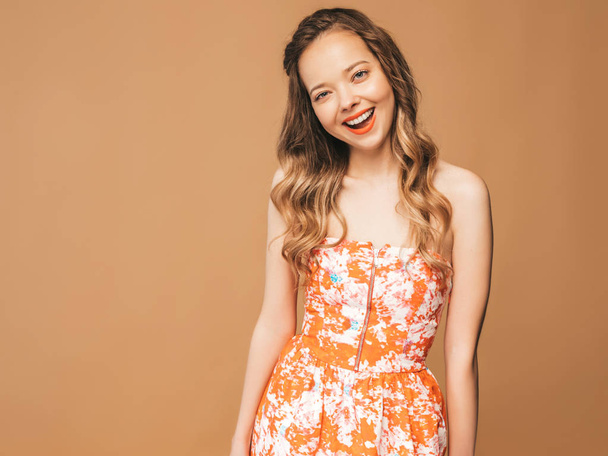 Portrait of beautiful smiling cute model with pink lips. Girl in summer hipster colorful dress. Model posing on golden background - Fotoğraf, Görsel