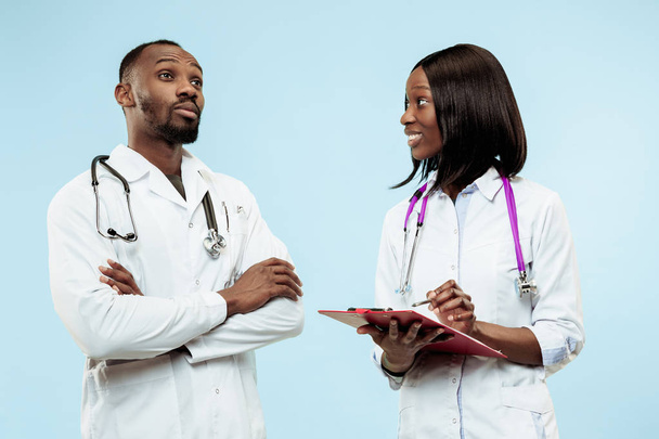 The female and male f happy afro american doctors on blue background - Foto, imagen