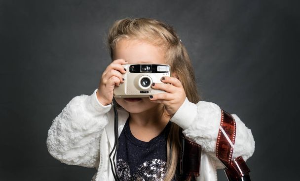 Piccola bella ragazza con una vecchia macchina fotografica. Giovane fotografo
 - Foto, immagini