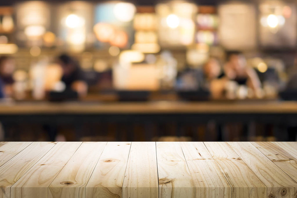 Κενό ξύλινο τραπέζι για το παρόν προϊόν σε καφετέρια ή αναψυκτικό μπαρ θολό φόντο με bokeh εικόνα - Φωτογραφία, εικόνα