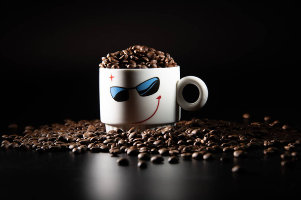 xícaras brancas com um padrão e grãos de café em um fundo preto
 - Foto, Imagem