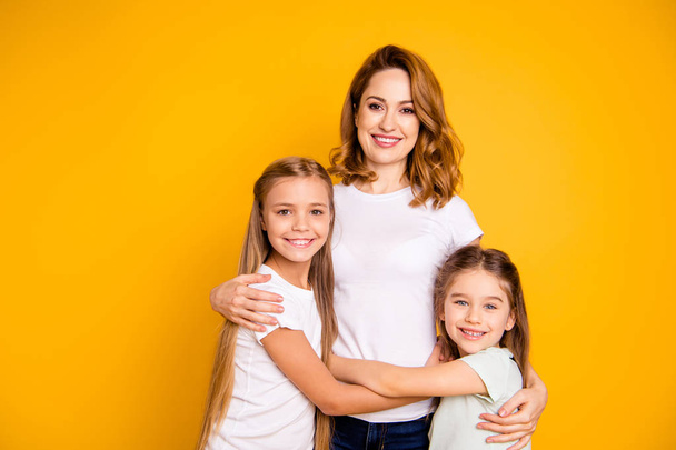 Portrait of three nice adorable attractive cheerful people hugging spending time together mum mommy isolated over bright vivid shine yellow background - Foto, immagini