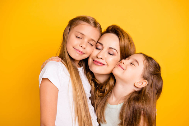 Close-up portrait of three nice cute adorable sweet tender attractive cheerful caucasian people cuddling mum mommy closed eyes isolated over bright vivid shine yellow background - Fotó, kép