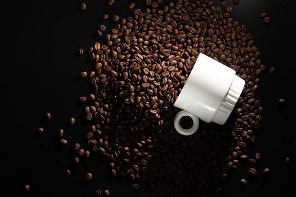 λευκό φλυτζάνια με ένα μοτίβο και κόκκους καφέ σε μαύρο φόντο - Φωτογραφία, εικόνα