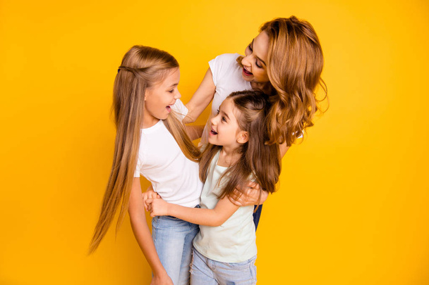 Portrait of three nice cute winsome lovely lovable sweet tender attractive cheerful people cuddling mum mommy having fun spending time isolated over bright vivid shine yellow background - 写真・画像