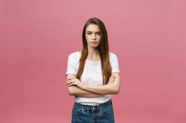 Portrait of a happy woman standing with arms folded isolated on a pink background - Foto, imagen