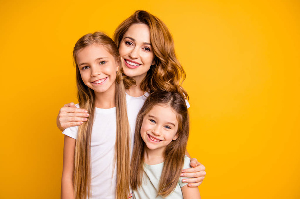 Portrait of three nice cute lovely winsome attractive cheerful cheery blonde positive people cuddling bonding relatives isolated over bright vivid shine yellow background - Photo, image