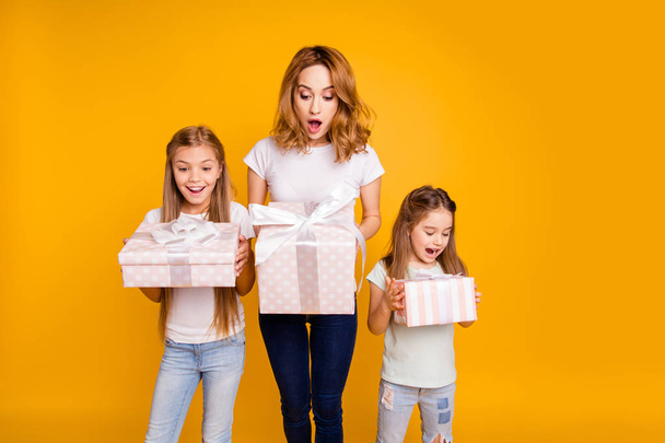 Portrait of three nice cute lovely winsome attractive cheerful positive curious impressed funny people holding in hands boxes great day isolated over bright vivid shine yellow background - Photo, Image
