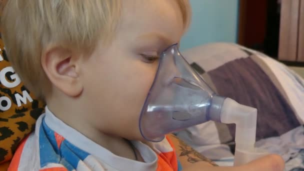 Le garçon respire à travers un masque à oxygène. L'enfant prend des inhalations de toux, de grippe et de maladies virales. L'enfant respire à travers le masque médical inhalateur
. - Séquence, vidéo