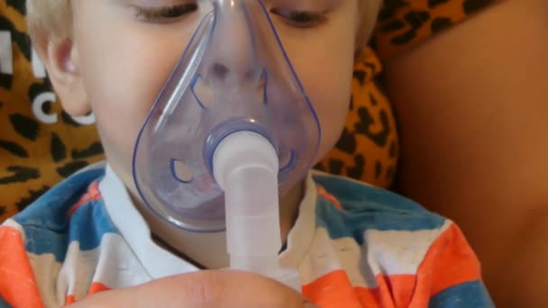 O rapaz respira através de uma máscara de oxigénio. A criança toma inalações de tosse, gripe e doenças virais. A criança respira através da máscara médica inalador
. - Filmagem, Vídeo