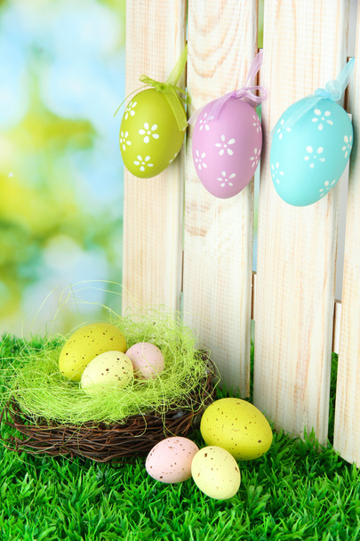 Art Easter background with eggs hanging on fence - Foto, afbeelding