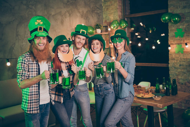 Close up photo company hands arms raise irish beer stylish eyeglasses specs national culture tradition leprechaun hats checkered plaid jeans shirts fake false beard mustache laugh laughter festive - Foto, afbeelding