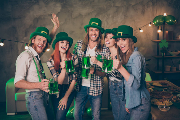 Clover leaf leprechaun hats costume tradition beer in hands arms pub bar company in circle weekend vacation screaming shouting yelling group of five drunk carefree crazy people - Photo, image