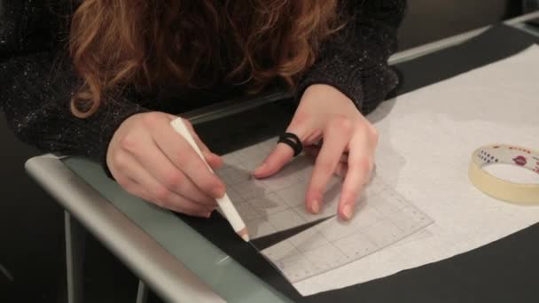 Dívka kreslí papír vzor s pravítko a tužka, za oblek na míru. - Záběry, video