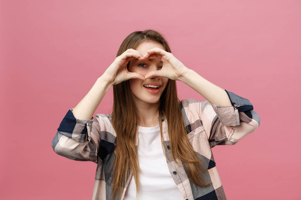 Lifestyle Concept: Beautiful attractive woman in white shirt making a heart symbol with her hands - Valokuva, kuva