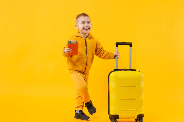 Mały podróżnik turystycznych dziecko chłopiec 3-4 lat na białym tle na studio tło żółte pomarańczowe ściany. Pasażera podróżowania za granicą, podróż na weekendy wypad. Powietrze lot podróż koncepcja. Makieta kopiować przestrzeń - Zdjęcie, obraz