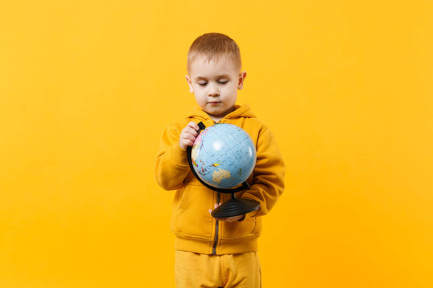 Little cute kid boy wearing yellow clothes hold Earth world glob - Photo, Image