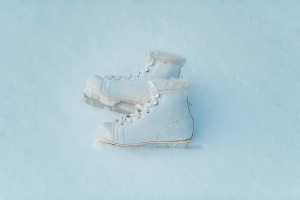 Par de patines de hielo blanco en fondo de nieve
 - Foto, imagen