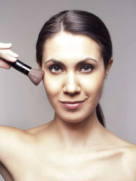 Woman applying makeup with brush - Valokuva, kuva