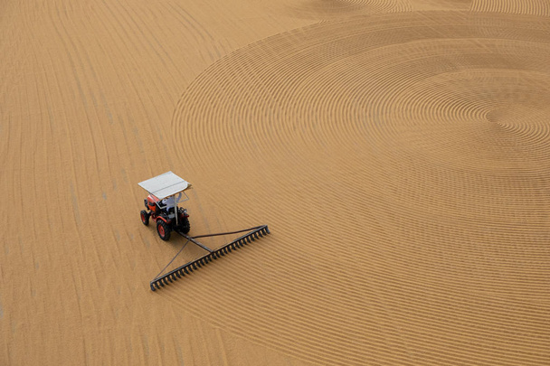 tractor flattening cracked wheat for drying - Photo, Image