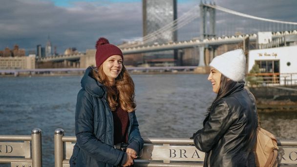 Two friends in New York take a walk at Brooklyn Bridge - 写真・画像