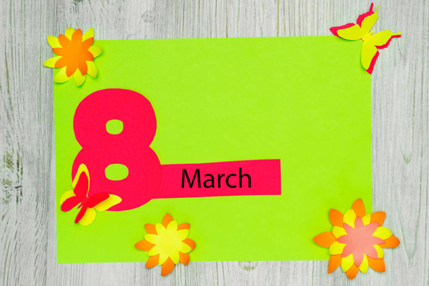 Tarjeta de felicitación hecha a mano. La inscripción 8 de marzo y las flores y mariposas de papel. Acostado. Copiar espacio
 - Foto, imagen