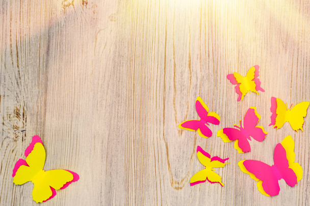 Borboletas de papel coloridas em fundo de madeira. Atividade de desenvolvimento infantil. Aplicação e origami. Espaço de cópia
 - Foto, Imagem