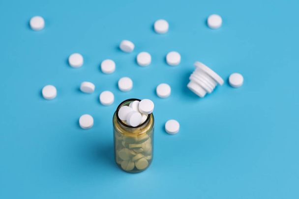 Асорті таблетки фармацевтичної медицини, білі таблетки в скляній пляшці на помаранчевому тлі. Копіювати простір для тексту
 - Фото, зображення