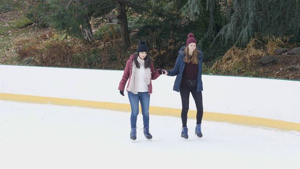 Girls have a lot of fun doing ice skating in New Yorks Central Park - 写真・画像