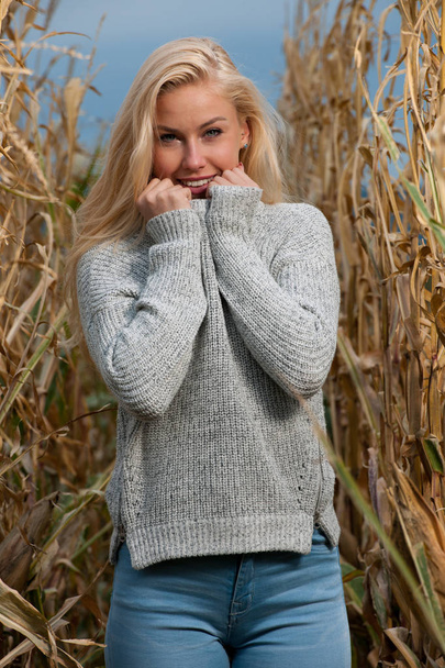 Blog style fashion photo of cute blond woman on corn field in late autumn - Фото, изображение