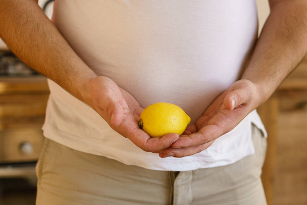 vegetarian overweight man with lemon in hands - Фото, изображение