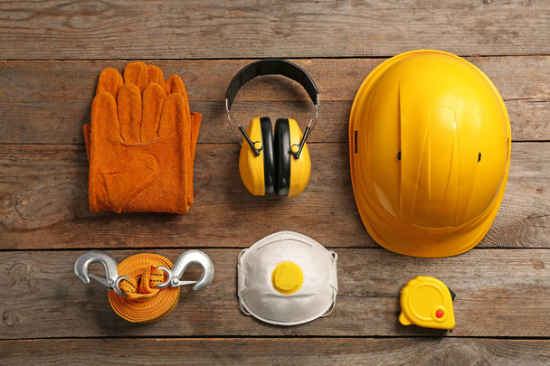 Flat lay composition with safety equipment on wooden background - Foto, afbeelding