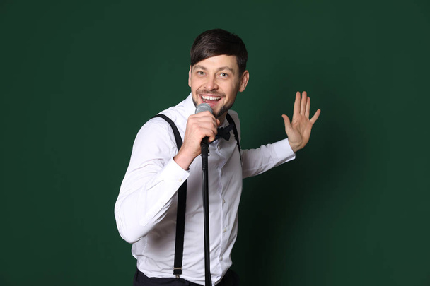 Handsome man in casual clothes with microphone on color background - Fotoğraf, Görsel