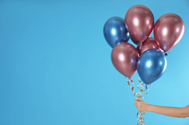 Woman holding bunch of balloons on color background, closeup. Space for text - Φωτογραφία, εικόνα