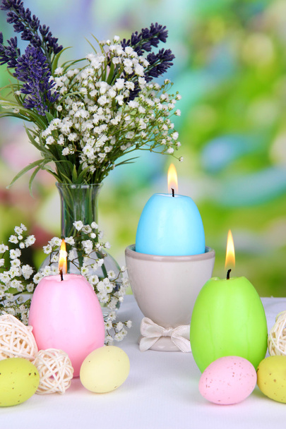Easter candles with flowers on bright background - Фото, изображение