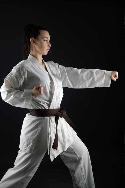 Νεαρή γυναίκα εξάσκηση με την πολεμική τέχνη του Karate - Φωτογραφία, εικόνα