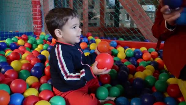 toddler with mother playing with colorful balls in child playing area - early development - Footage, Video