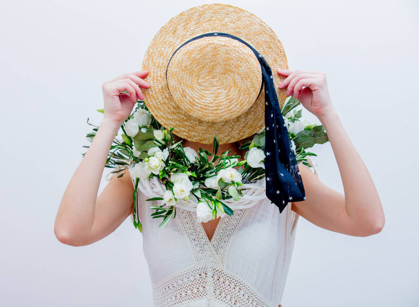 Mooie vrouw met witte rozen krans op witte achtergrond - Foto, afbeelding