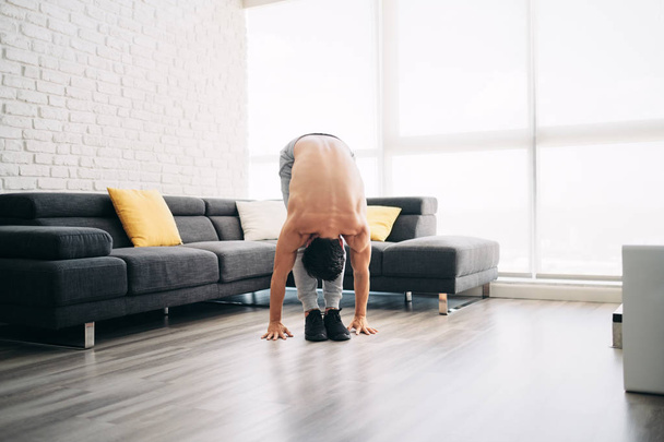 Homem praticando Yoga em casa fazendo sol rotina de saudação
 - Foto, Imagem