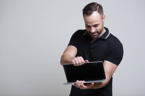 Giovane uomo fiducioso apertura computer portatile su sfondo bianco
 - Foto, immagini