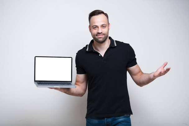 Молодий усміхнений чоловік тримає ноутбук з маком на білому тлі
 - Фото, зображення