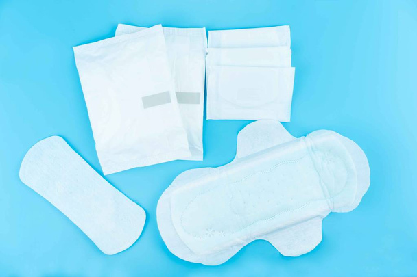 Sanitary pads and absorbent sheets on a blue background - Photo, Image